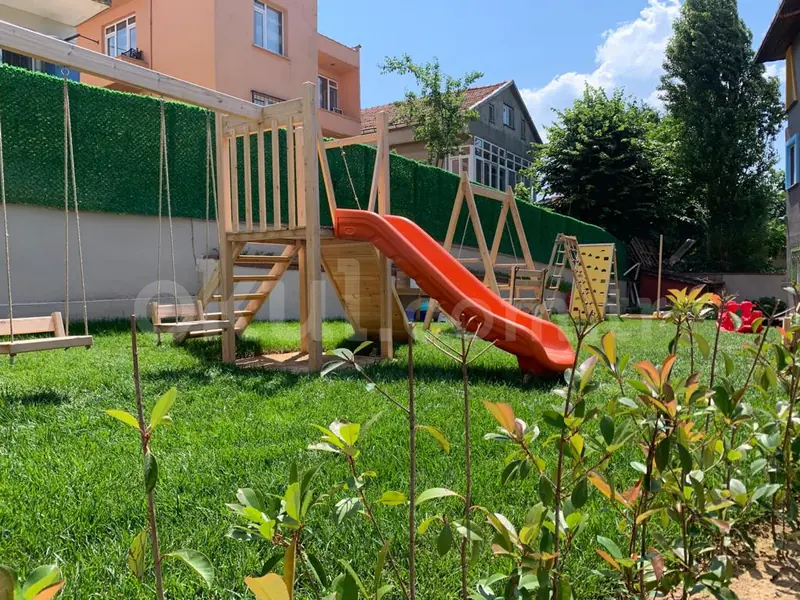 Wooden play house and slide in the school garden
